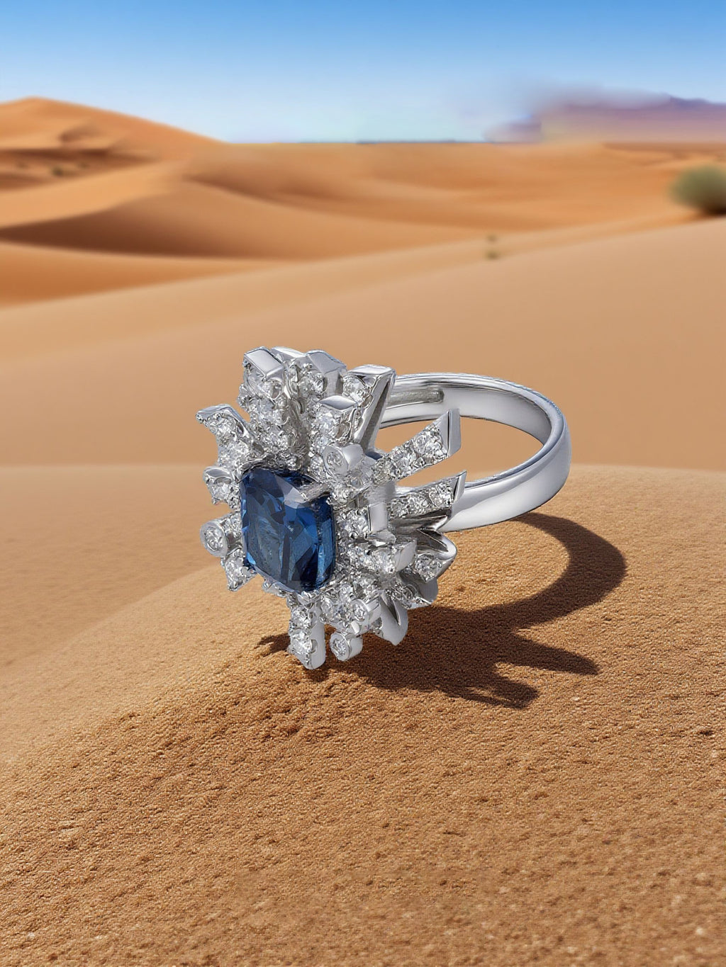 Own Your Bloom Blue Sapphire Floral Ring displayed on soft sand backdrop, reflecting desert-inspired elegance and royal charm, Miami.