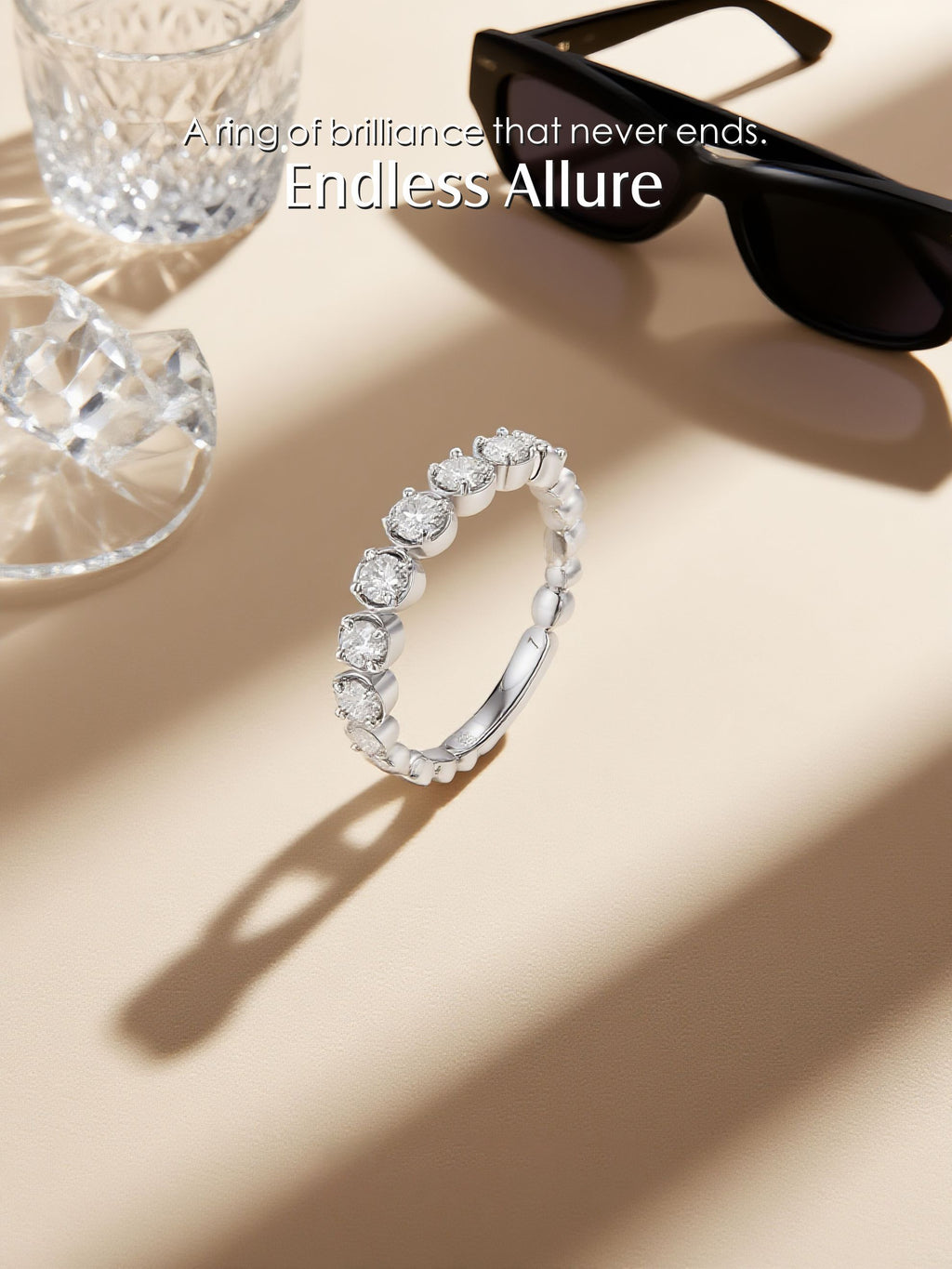 Own Your Bloom Endless Allure diamond eternity band displayed under studio light beside glass crystal, elegant fine jewelry, Miami.
