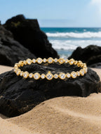 Own Your Bloom diamond tennis bracelet showcased on beach sand with ocean backdrop, capturing brilliance and sophistication, Dallas.