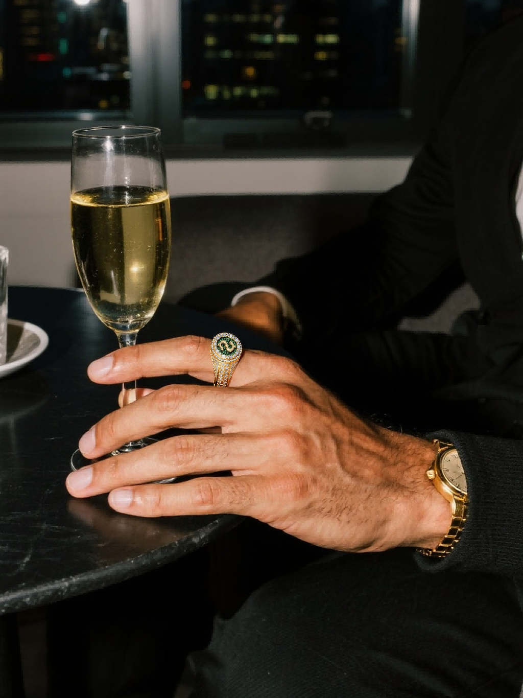 Male model wearing Own Your Bloom 14K gold-plated dollar sign signet ring with pavé stones in an evening scene.