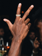 Hand holding a champagne flute while wearing the Own Your Bloom white-gold-plated double-row eternity ring.