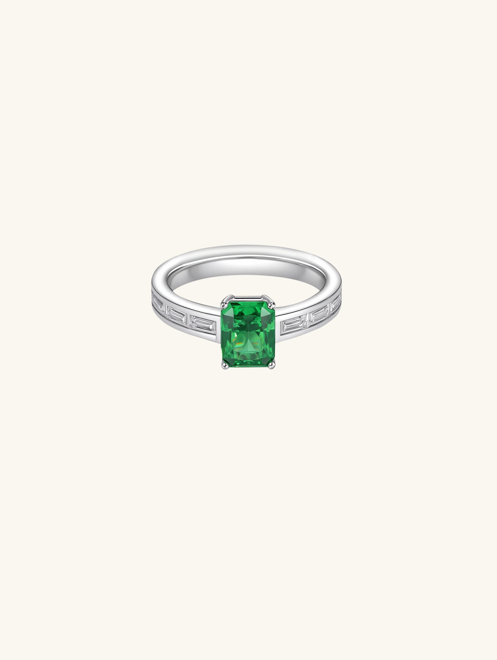 Own Your Bloom emerald cut diamond ring side angle showcasing rectangular baguette diamonds and green center stone, Los Angeles.
