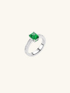 Own Your Bloom emerald cut baguette side ring front view with vivid green gemstone and white gold band, New York.