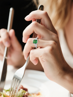 Own Your Bloom emerald cut green diamond ring on woman’s hand while dining, modern luxury jewelry look, Los Angeles.