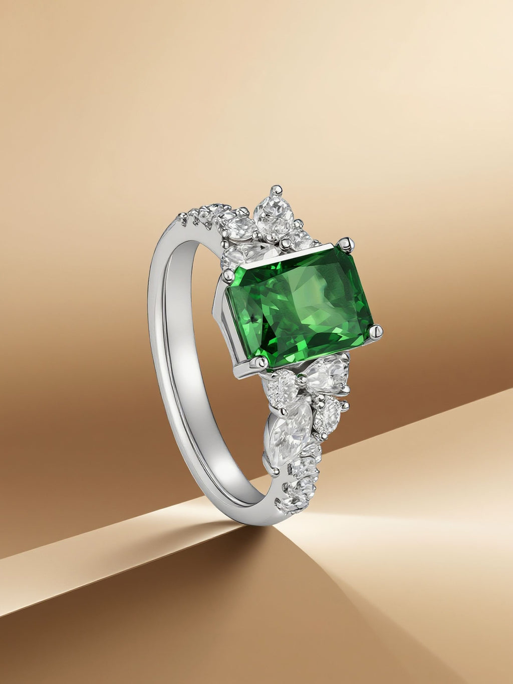 Own Your Bloom emerald cut green gemstone cluster ring displayed on golden background with soft lighting, Miami.