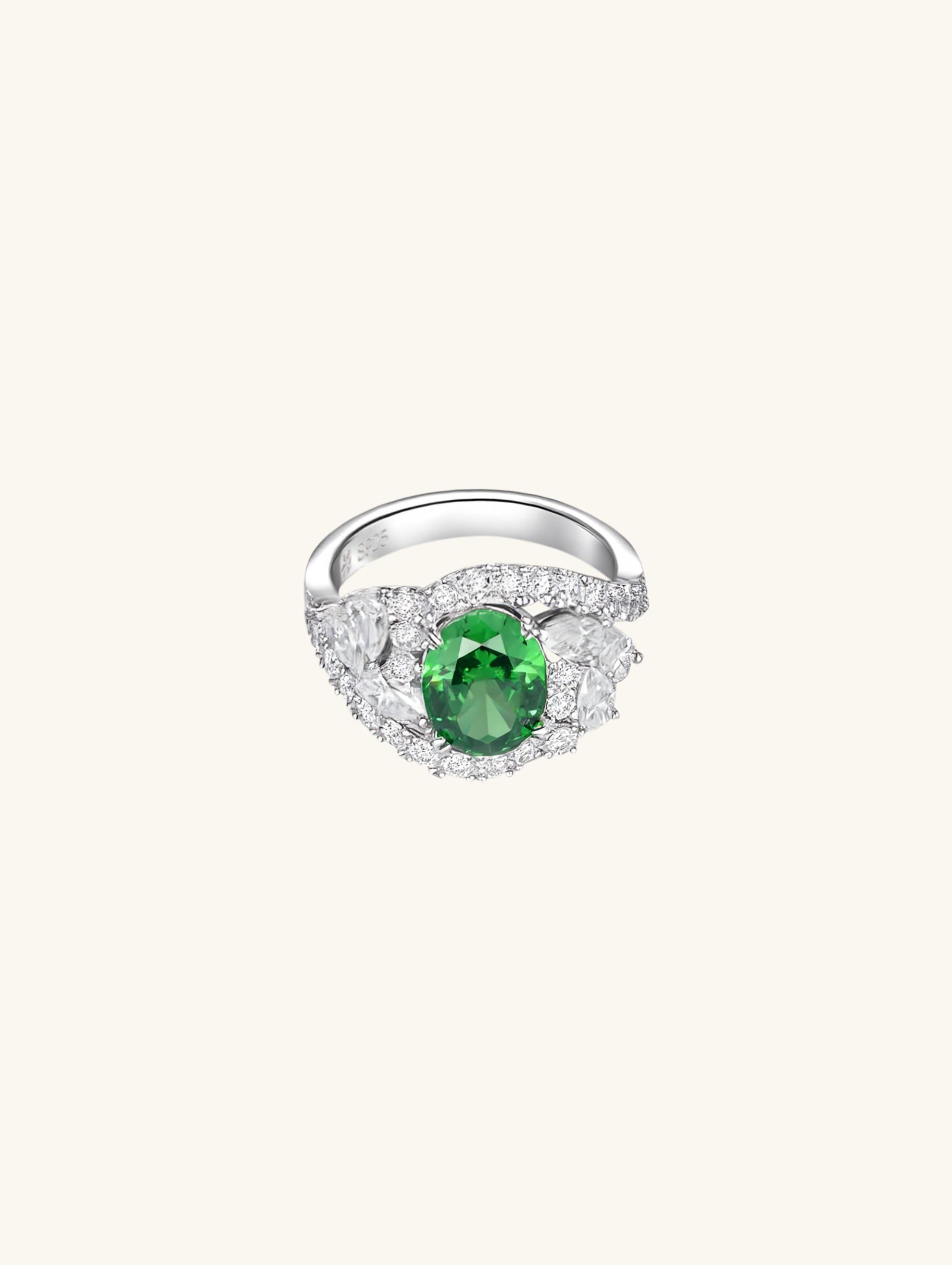 Own Your Bloom emerald oval halo diamond ring front view showcasing vibrant green gemstone with diamond halo, New York.