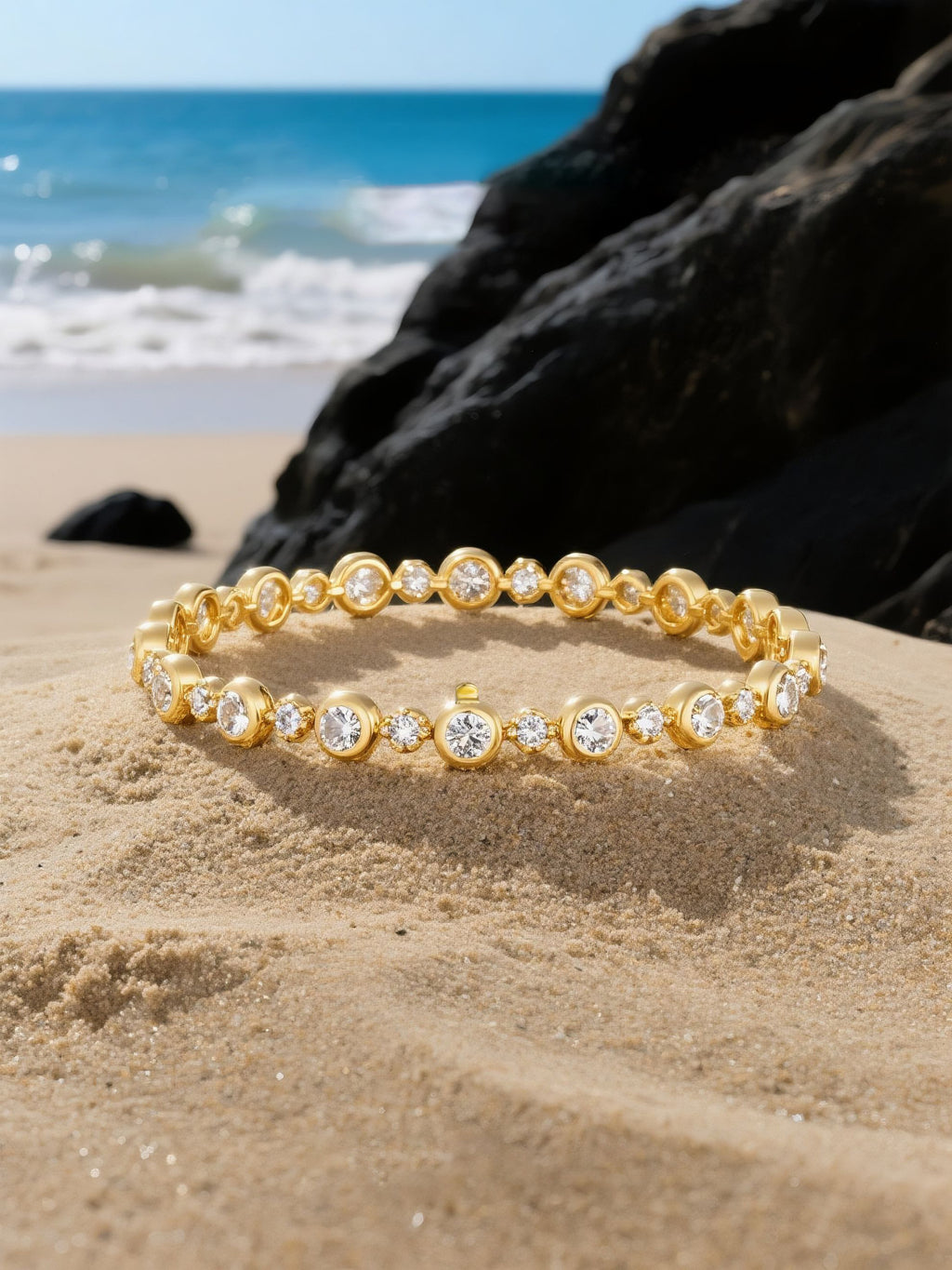 Own Your Bloom gold diamond tennis bracelet arranged on natural rock setting by the coast, timeless fine jewelry craftsmanship, Boston.
