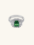 Own Your Bloom emerald halo baguette round ring front view in white gold, featuring green gemstone center surrounded by round diamonds, fine jewelry, New York.