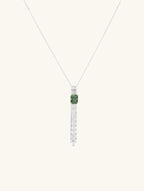 Own Your Bloom green gemstone tassel necklace front view in white gold, showcasing emerald-cut green gemstone with diamond tassel design, New York.