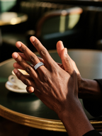 Own Your Bloom luxury 14K diamond ring on man’s hand under warm café lighting, timeless elegance, Los Angeles.