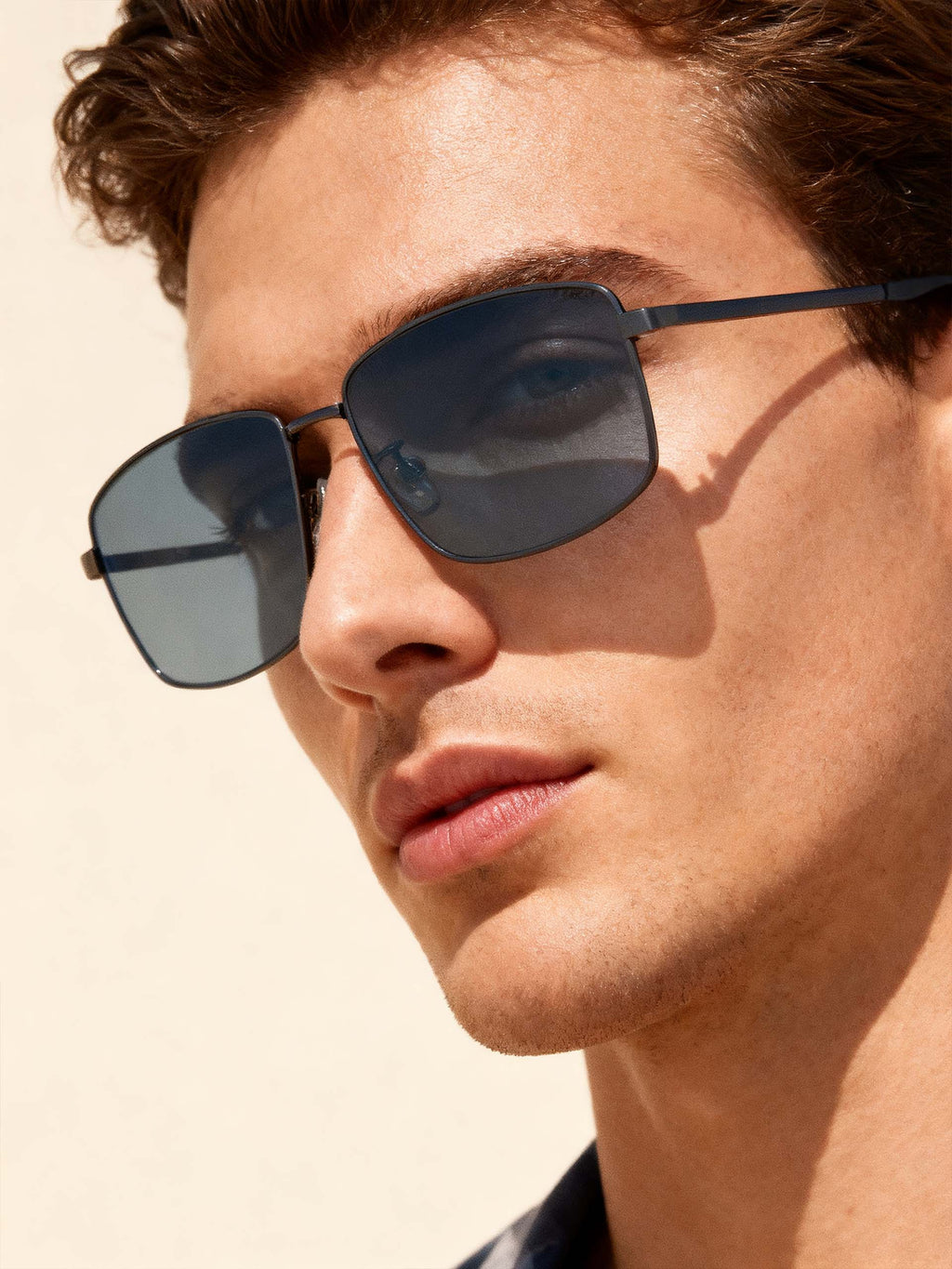 Own Your Bloom narrow frame business sunglasses on man close-up, modern men’s luxury eyewear, Los Angeles.