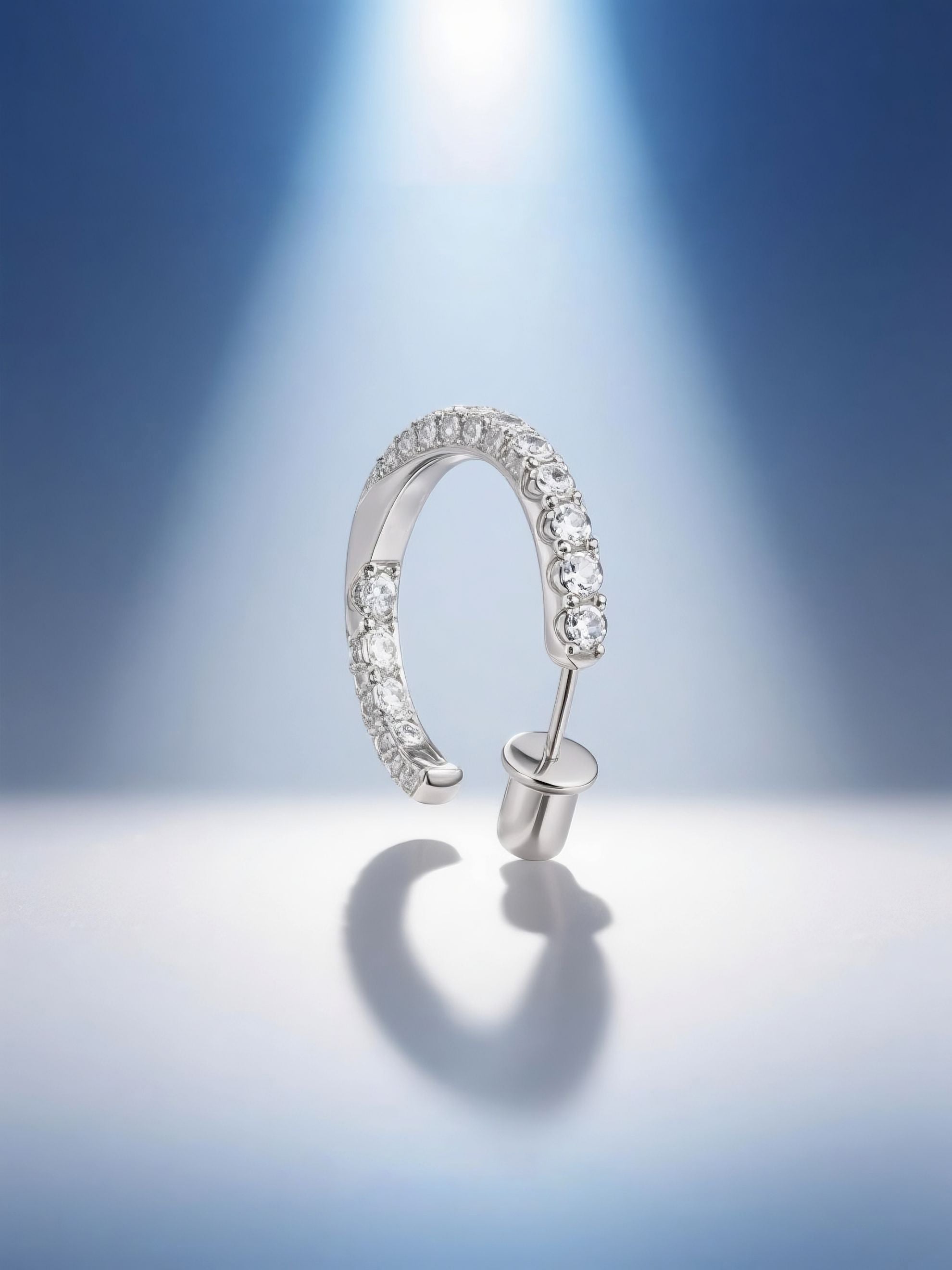 Own Your Bloom moissanite half hoop earrings illuminated by soft blue gradient lighting, modern luxury jewelry photography, Dallas.