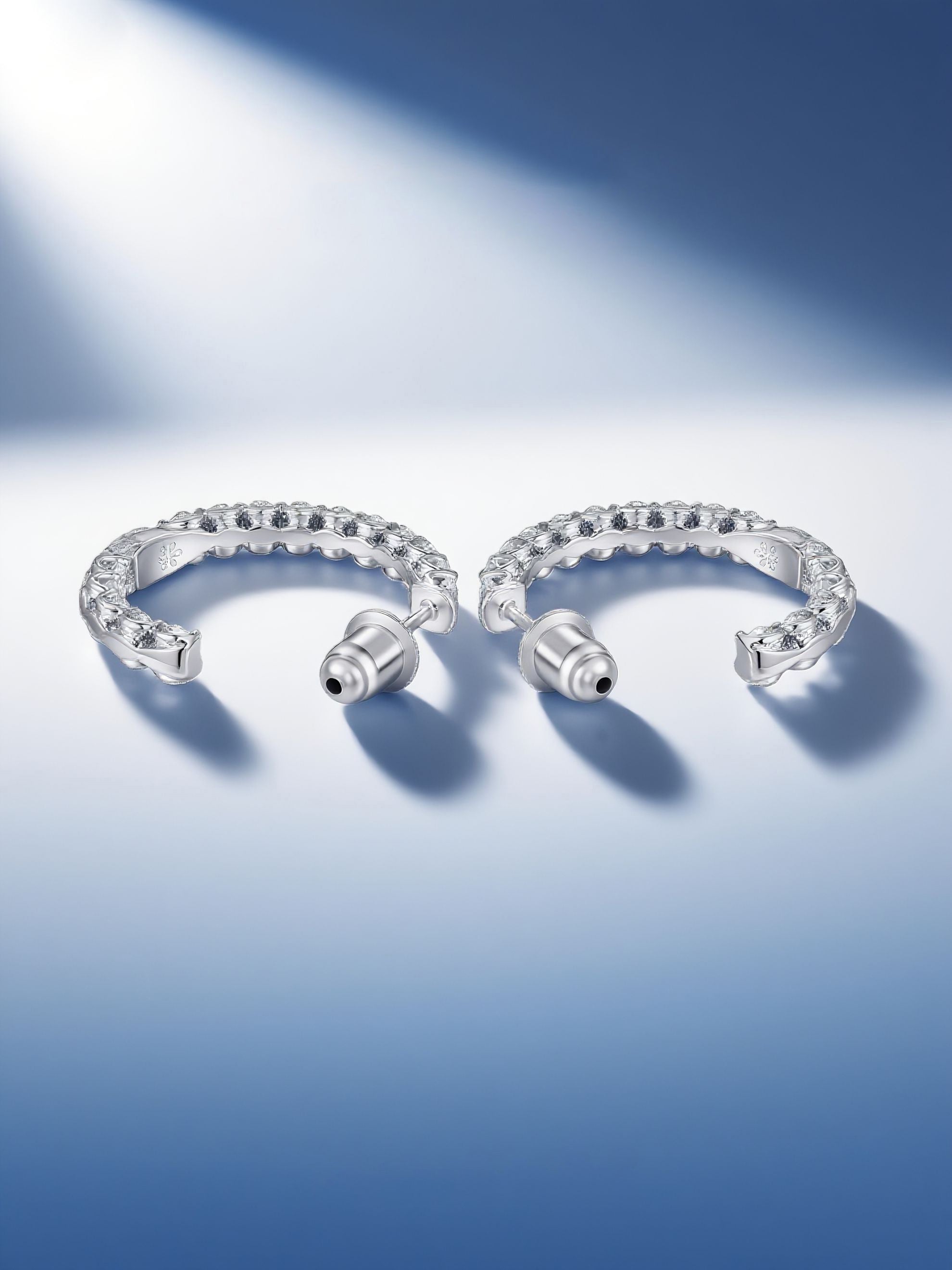 Own Your Bloom moissanite half hoop earrings on reflective background with cool tones, fine moissanite jewelry elegance, Boston.