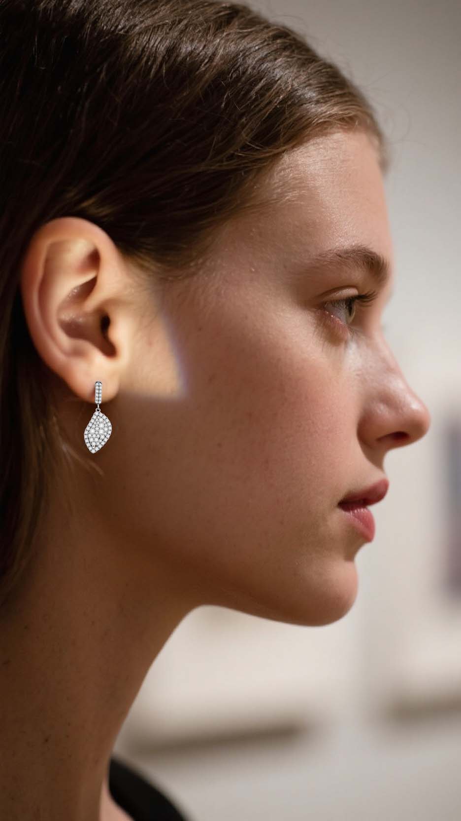 Own Your Bloom moissanite radiant drape earrings worn by woman in gallery light, elegant and modern fine jewelry, New York.