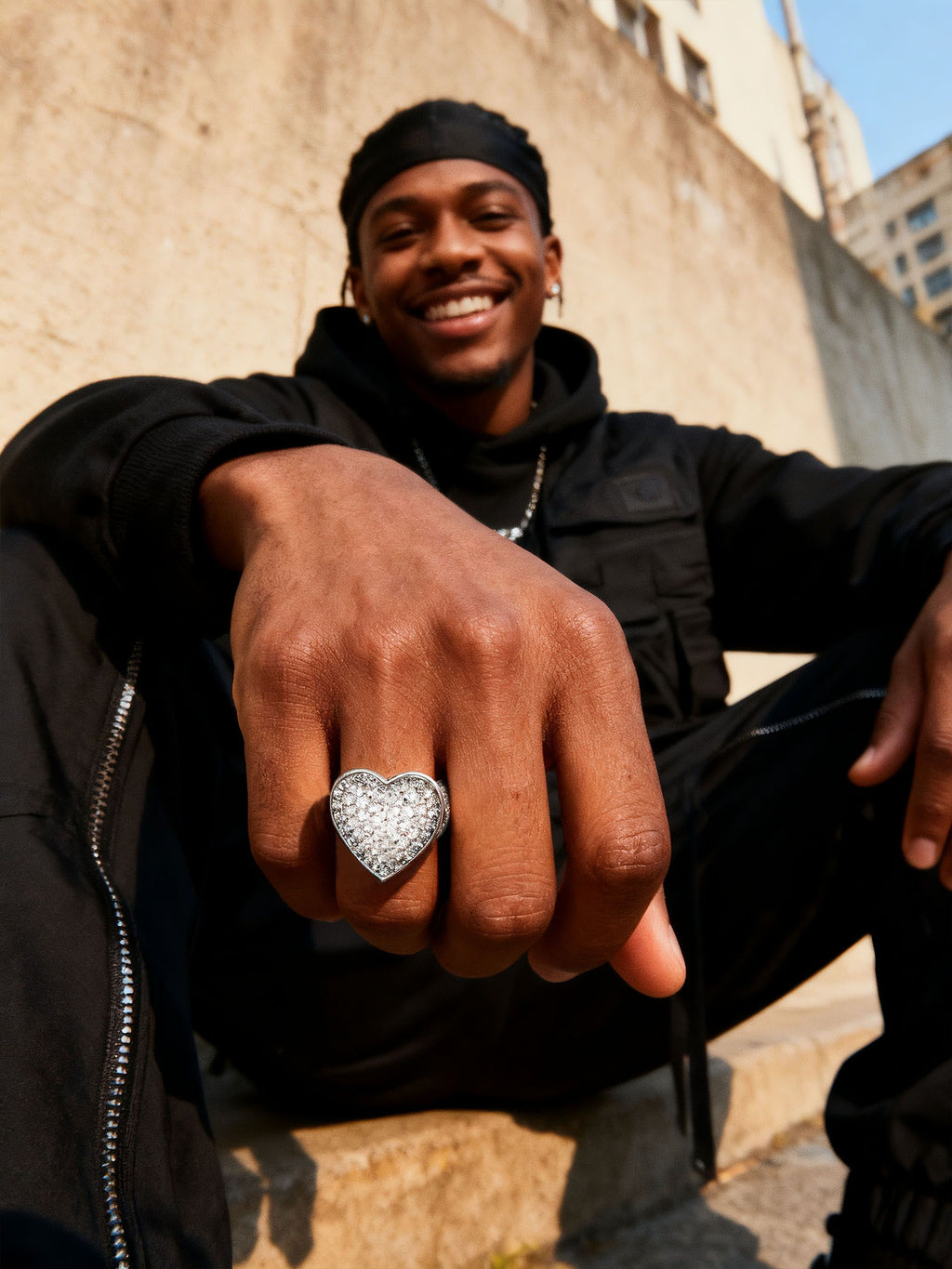 Man wearing Own Your Bloom 14K white gold–plated pavé heart ring in a street-style close-up, bold shine.