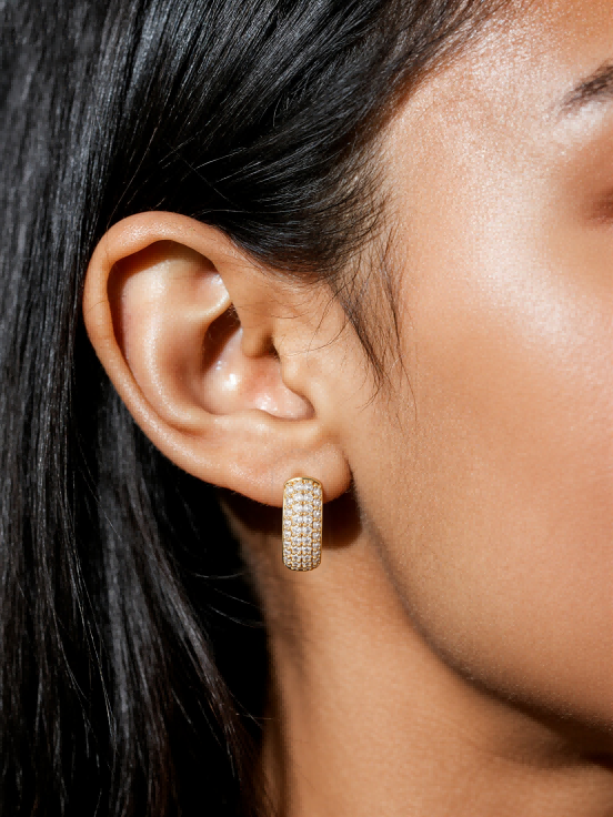 Lifestyle shot of Own Your Bloom gold-plated pavé hoop earring worn on ear.