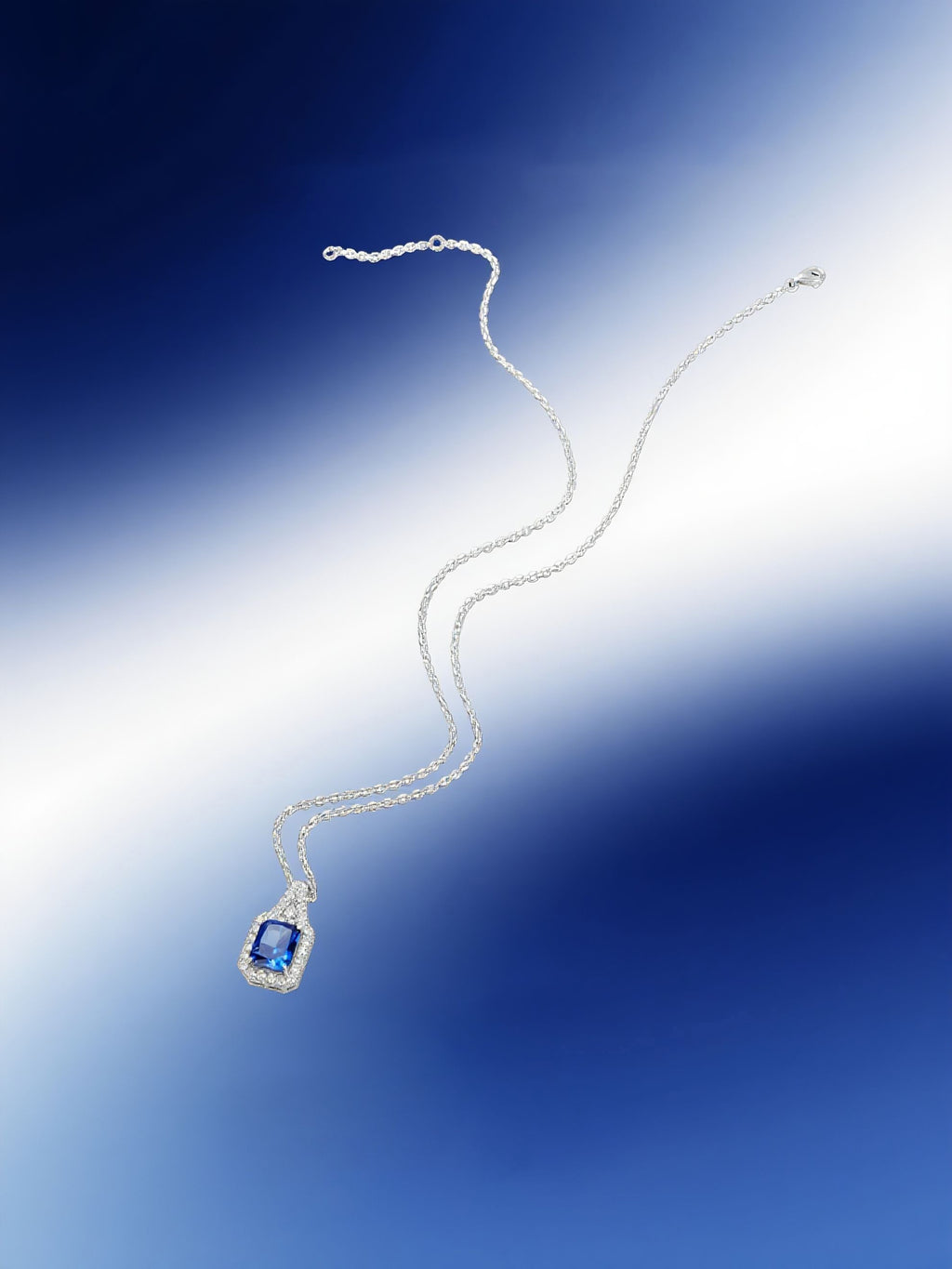 Own Your Bloom blue sapphire halo pendant showcased under soft gradient lighting with floating design aesthetic, Dallas.