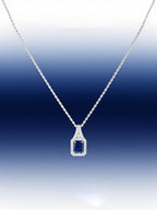 Own Your Bloom radiant blue sapphire necklace presented with gradient blue backdrop emphasizing gemstone depth and diamond brilliance, Boston.