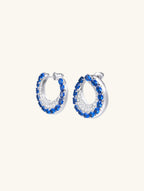 Own Your Bloom blue sapphire hoop earrings side view showcasing gemstone brilliance and modern curved design, Los Angeles.