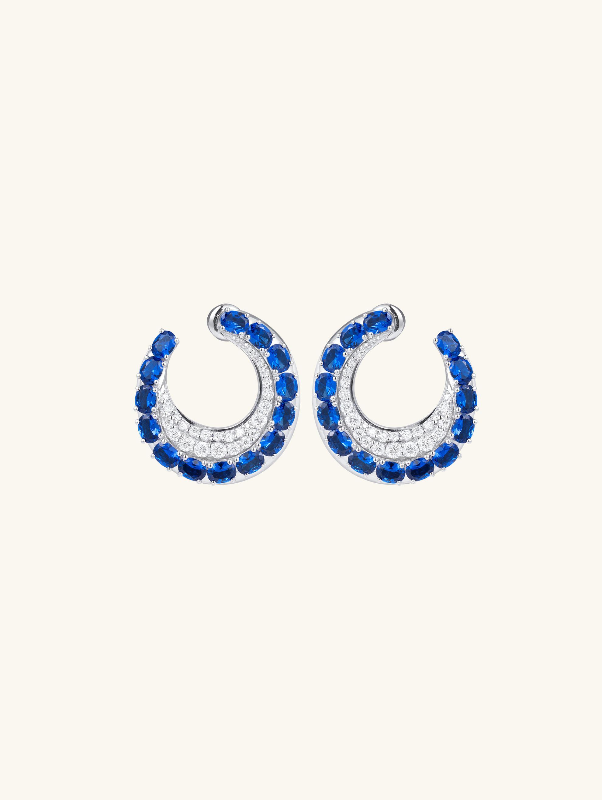 Own Your Bloom sapphire hoop earrings front view in white gold, featuring deep blue sapphires and diamond pavé detailing, New York.