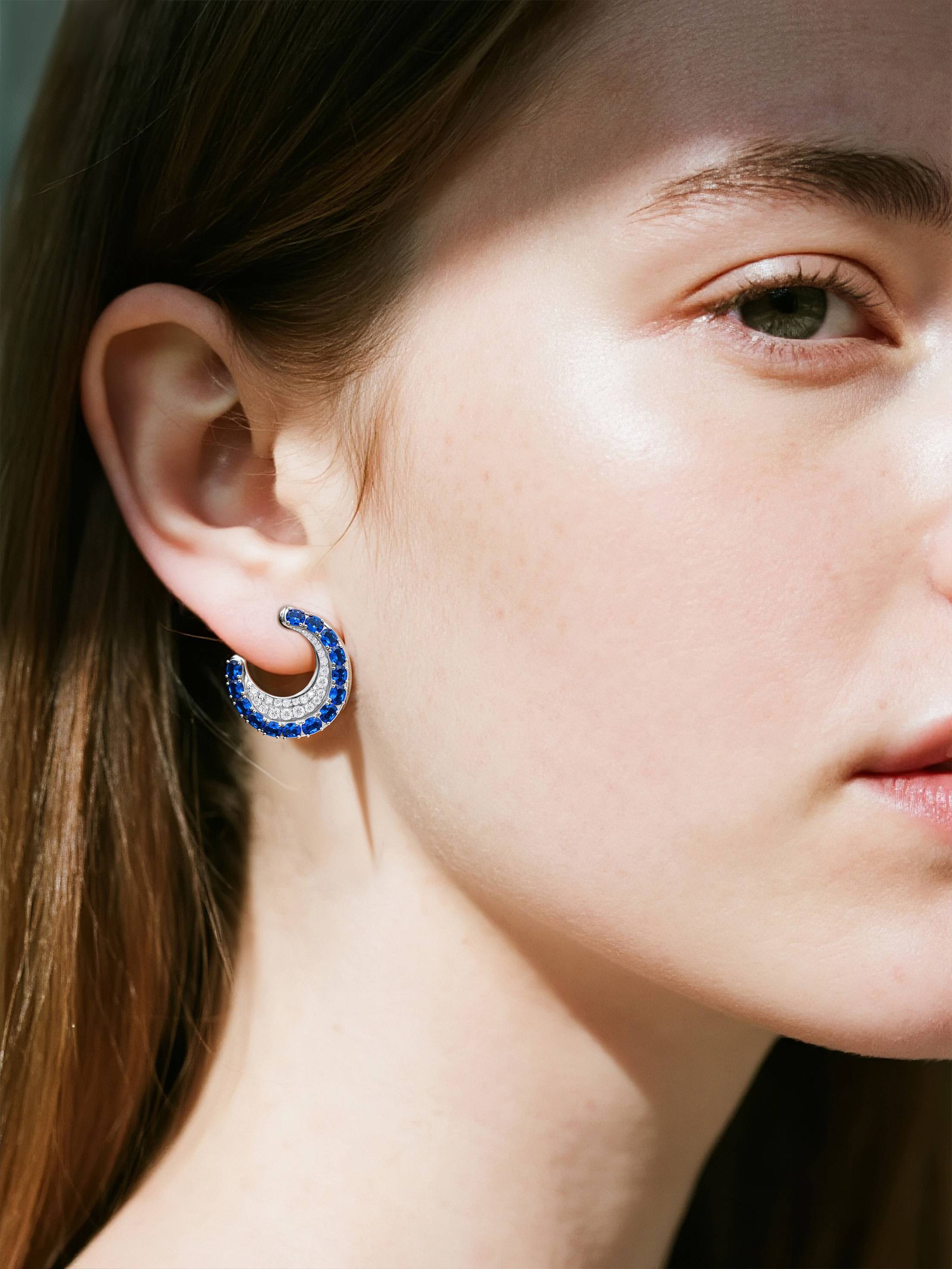 Own Your Bloom sapphire hoop earrings worn by woman, elegant blue gemstone jewelry radiating sophistication, New York.
