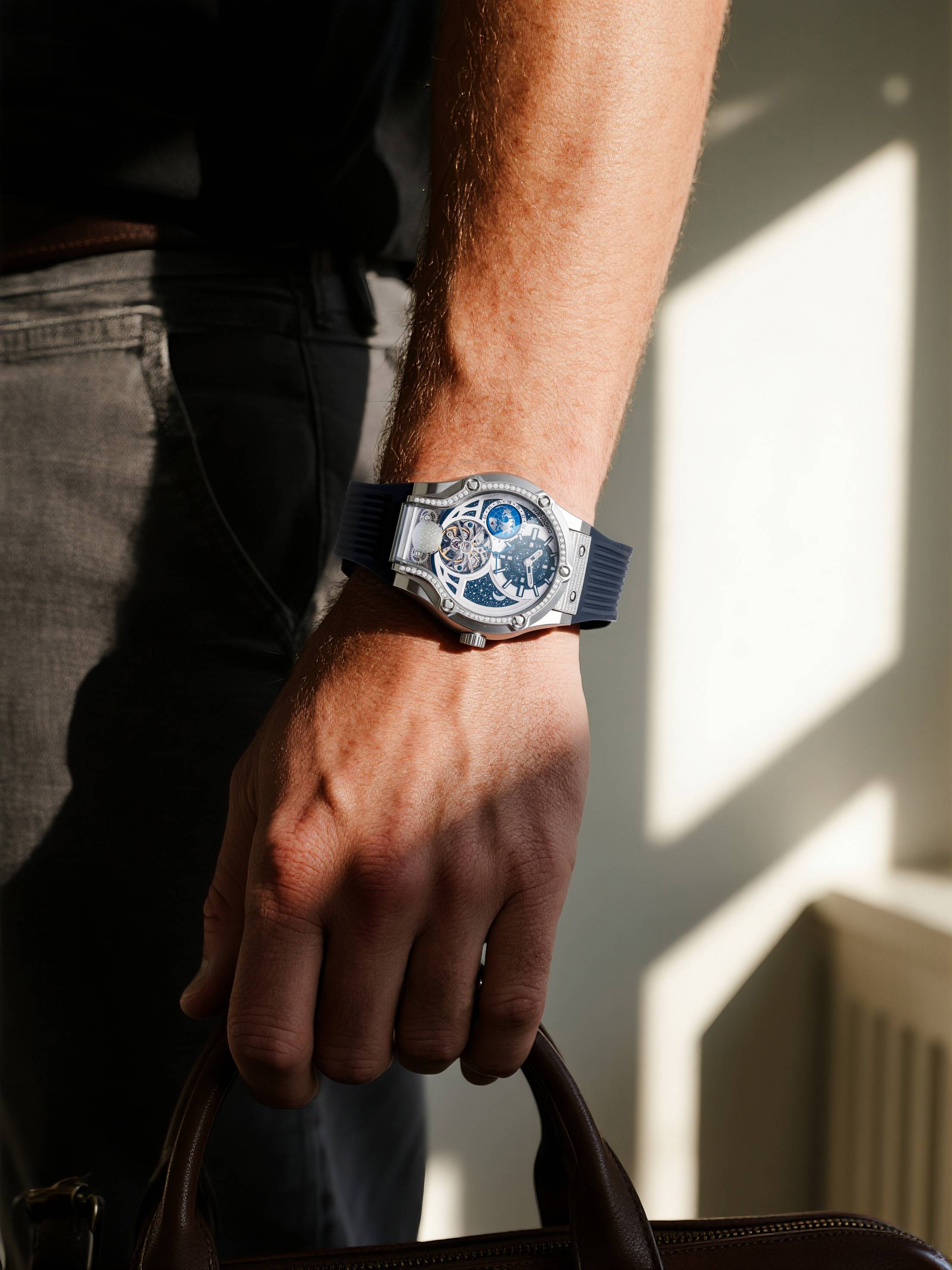 Own Your Bloom Starry Machine silver watch on wrist, man in suit at office, Boston.