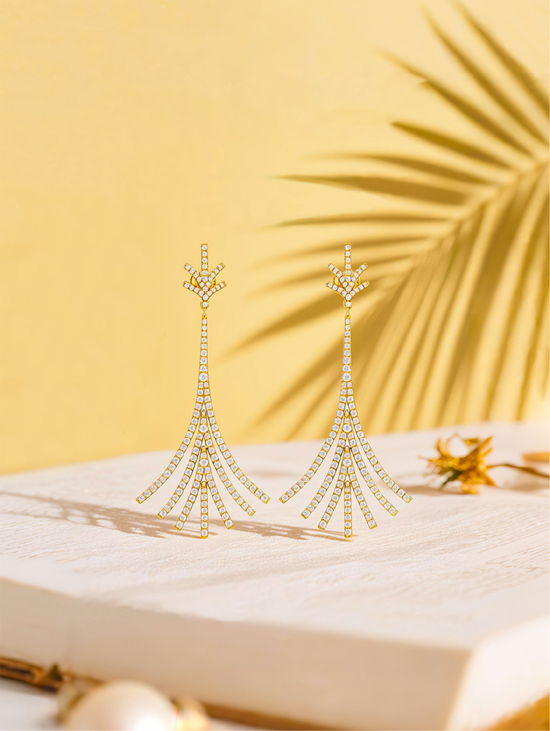 Own Your Bloom Twilight Bloom gold drop earrings displayed on soft beige fabric under warm sunlight, elegant minimalism, Miami.