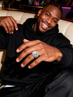 Close-up on hand showing the Own Your Bloom wide-band pavé ring with statement center stone.