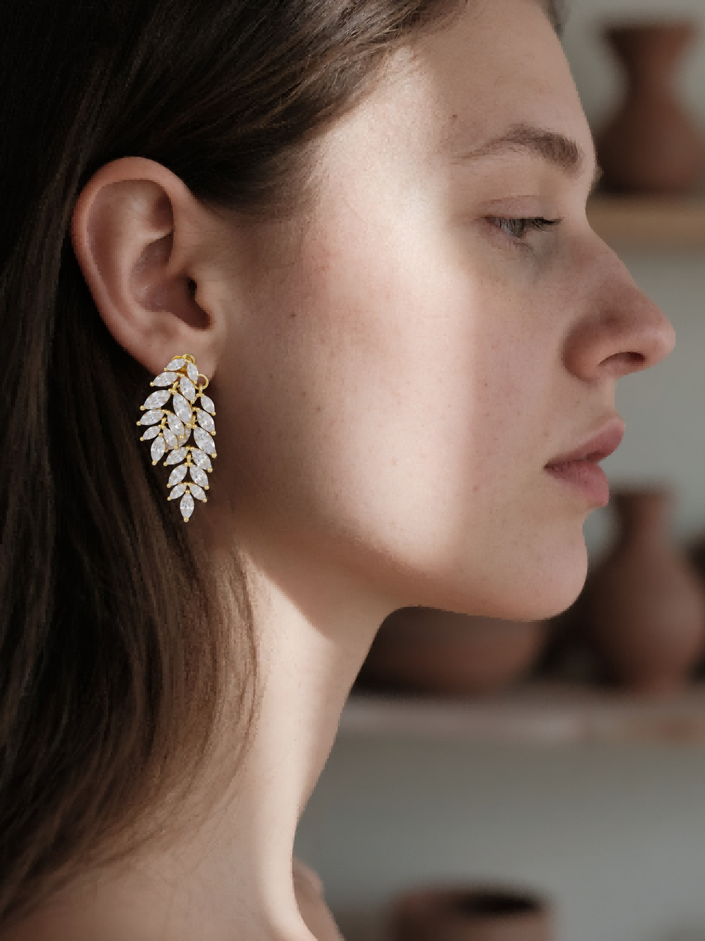 Elegant Own Your Bloom Willow Leaf diamond stud earrings on woman in white blouse, Houston.